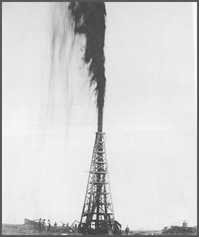 An oil pump spewing oil far into the air with a crew visible at the very bottom.