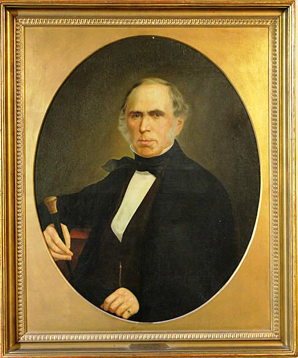 A framed circular portrait of an older man in a dark suit holding a cane.