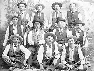 Eleven 1890s Rangers posing in vests and cowboy hats with their firearms.