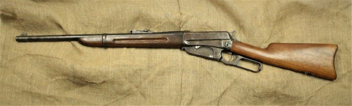 A rifle made up of a dark metal and lighter wood.