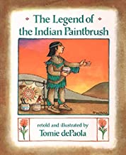 Book cover of "The Legend of the Indian Paintbrush" with a Native American boy standing in front of a painting with hills and the sunset in the background.