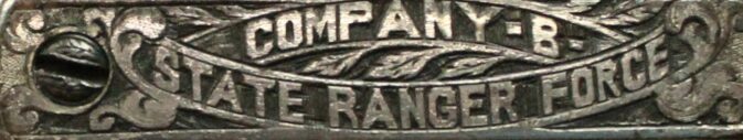 A close up image of a decorative silver surface that reads "Company -B- State Ranger Force".