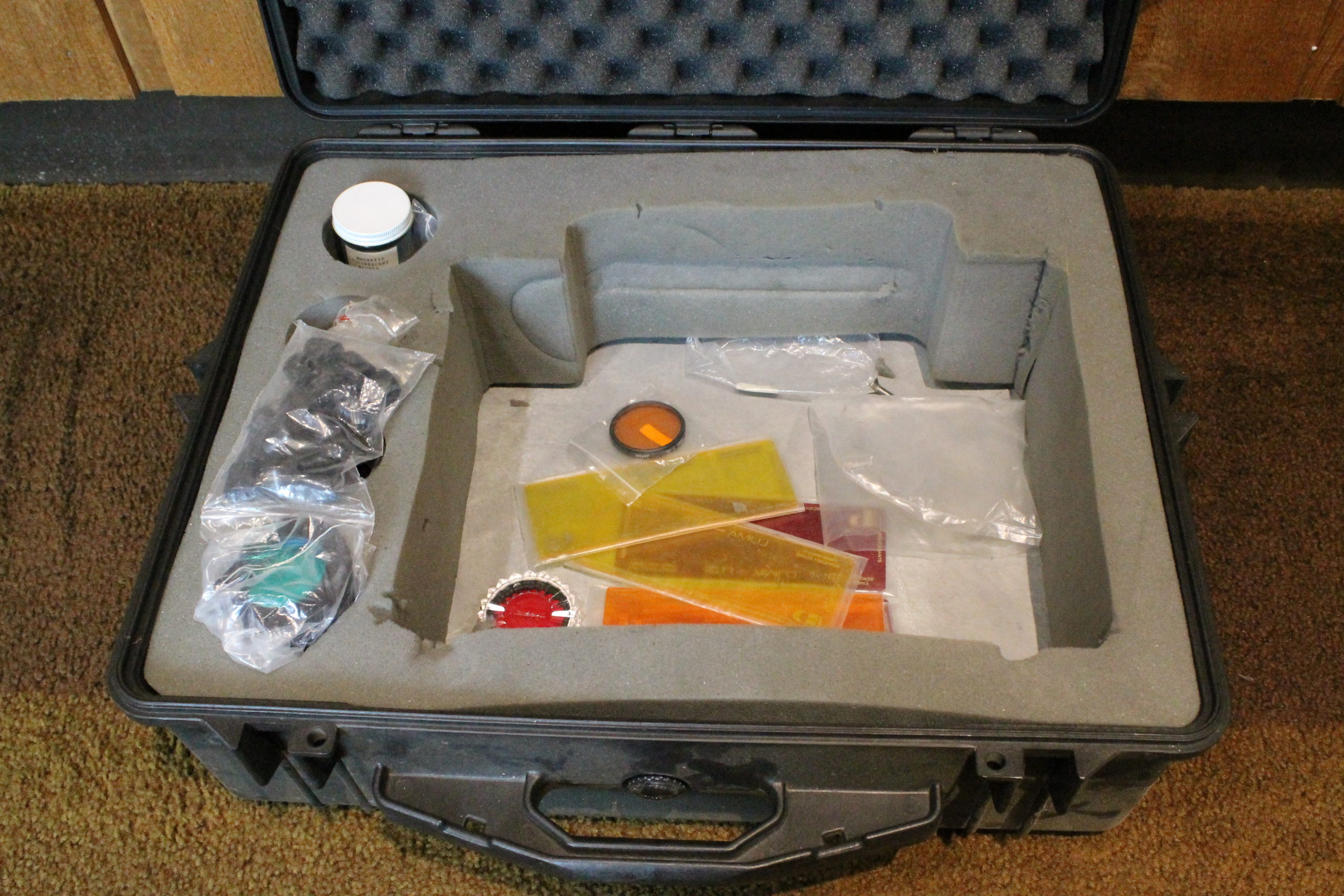 A padded box with various accessories in it such as colored lenses.