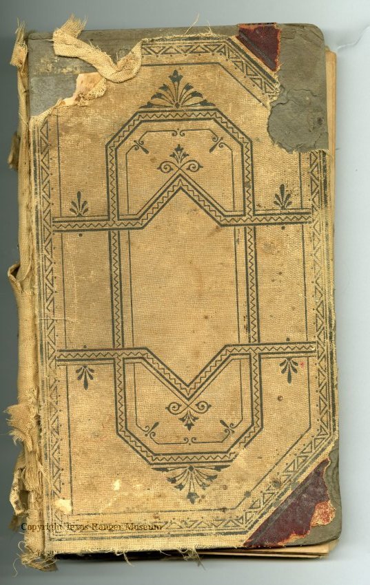 The back of an old tan tattered book with a dark blue/black geometric design on it.