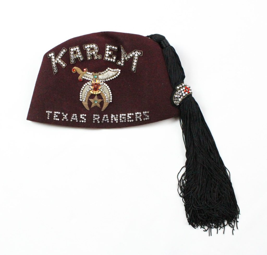 maroon hat with black tassle and embroidery