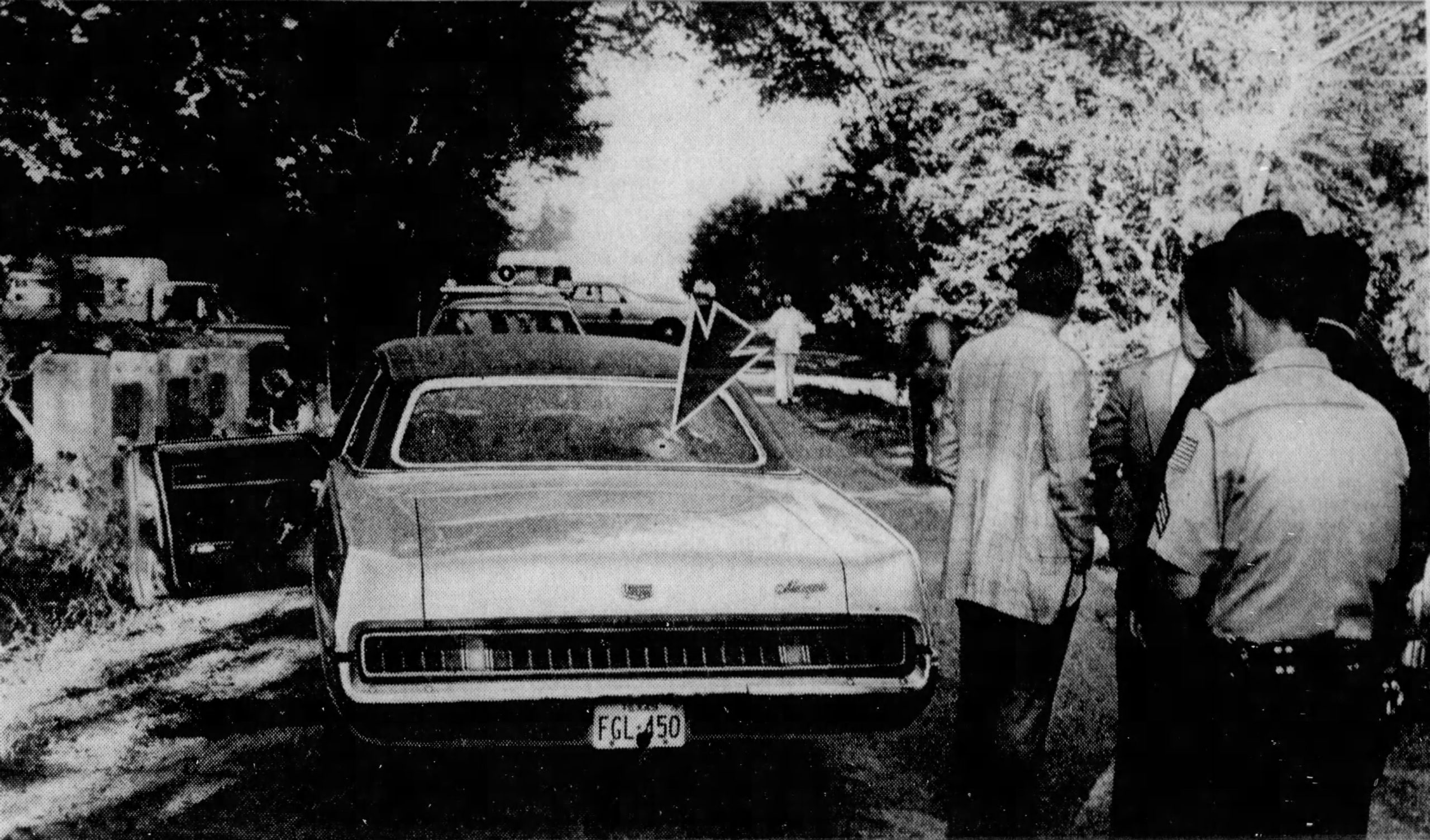 The Houston Family car with bullethole indicated, and people standing nearby.